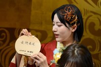 絵馬を記者陣に見せ、言葉の意味を説明する林瑠奈。