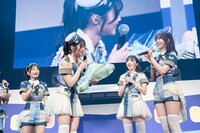 鶴見萌から青色の花束を受け取る山崎夏菜。