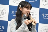 伊勢鈴蘭がプレゼンした「スモークフィッシュバー（にしん）」をかじる上國料萌衣。