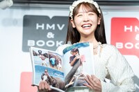 象に乗った写真を見せる櫻井優衣（FRUITS ZIPPER）。