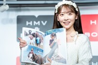 象に乗った写真を見せる櫻井優衣（FRUITS ZIPPER）。