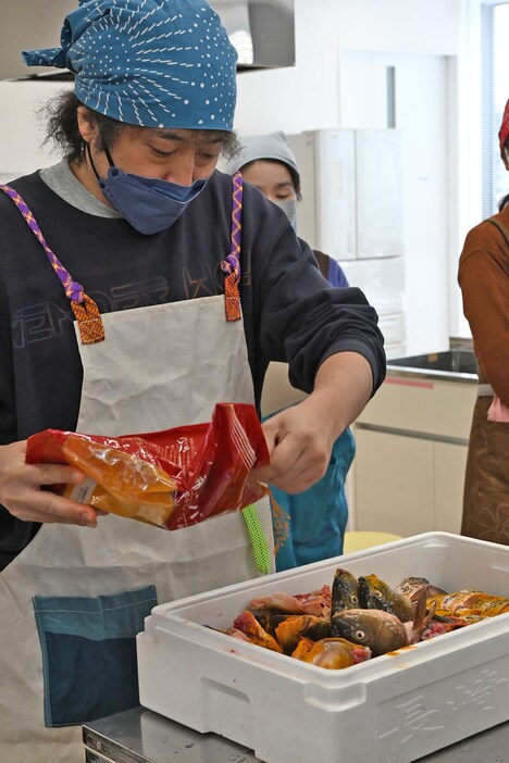 鯉の切り身にターメリックをまぶすU-zhaan。