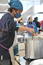 鍋をかき混ぜるU-zhaan。