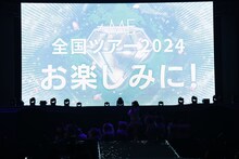 スクリーンに映し出された「≠ME 全国ツアー2024『やっと、同じクラス』」開催決定の知らせ。(c)YOANI