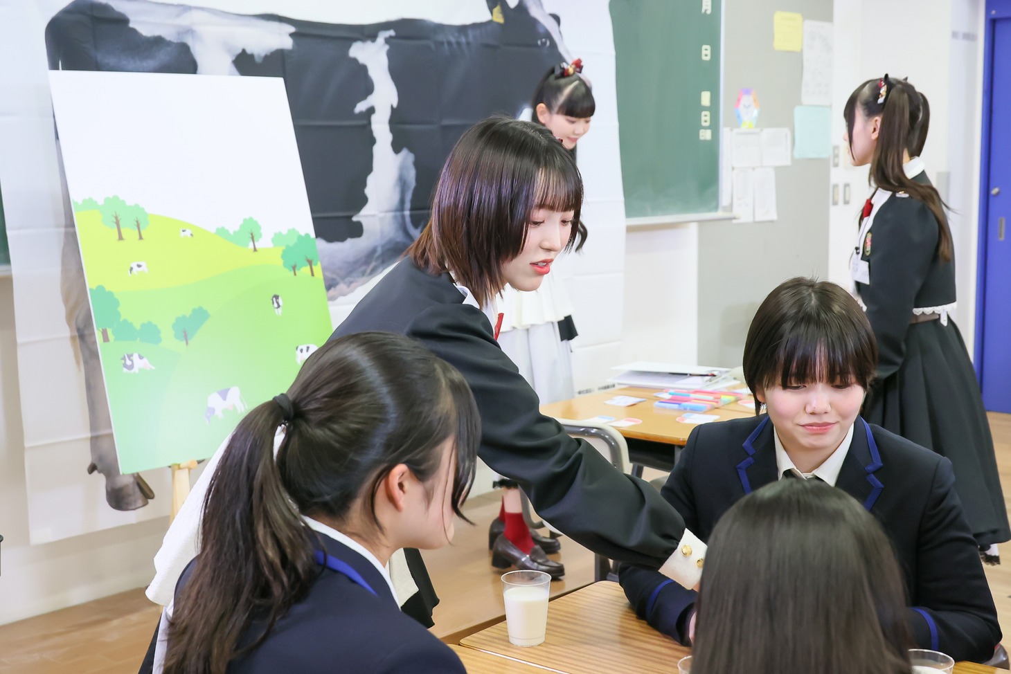 酪農の特別授業を行う高嶺のなでしこメンバー。