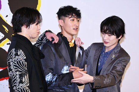 ポージングに迷う岩本照を導く深澤辰哉と見守る宮舘涼太。