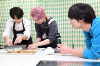 春巻を包むタカシとシューヤを撮影するアロハ（右）。