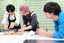 春巻を包むタカシとシューヤを撮影するアロハ（右）。