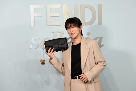 バッグとチャームをアピールする目黒蓮（Snow Man）。