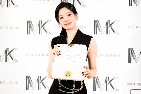 サインを入れた限定バッグ「TRIBECA ホワイトデニム」を見せるダヒョン（TWICE）。