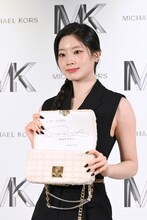 サインを入れた限定バッグ「TRIBECA ホワイトデニム」を見せるダヒョン（TWICE）。