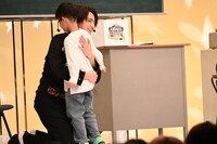 “面白かったお兄さん”に選ばれ、子供を抱き寄せるタカシ。