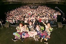 「カイジューバイミーONEMAN『怪獣爛漫』 」にて、フロアをバックに記念撮影するカイジューバイミーとプロデューサー・メルクマール祐。