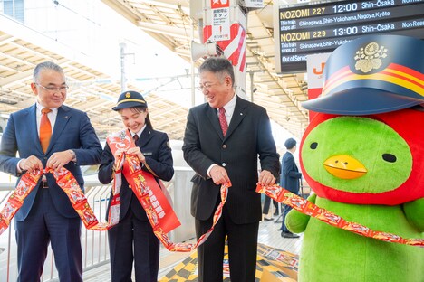 かっぱえびせんでテープカットを行うカルビーの江原信代表取締役社長、百田夏菜子、東海旅客鉄道の中村明彦副社長。