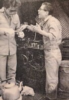 ノギスという測定器を使っている鈴木雅之（左）と、その不器用な姿を見て笑っている父親（右）。