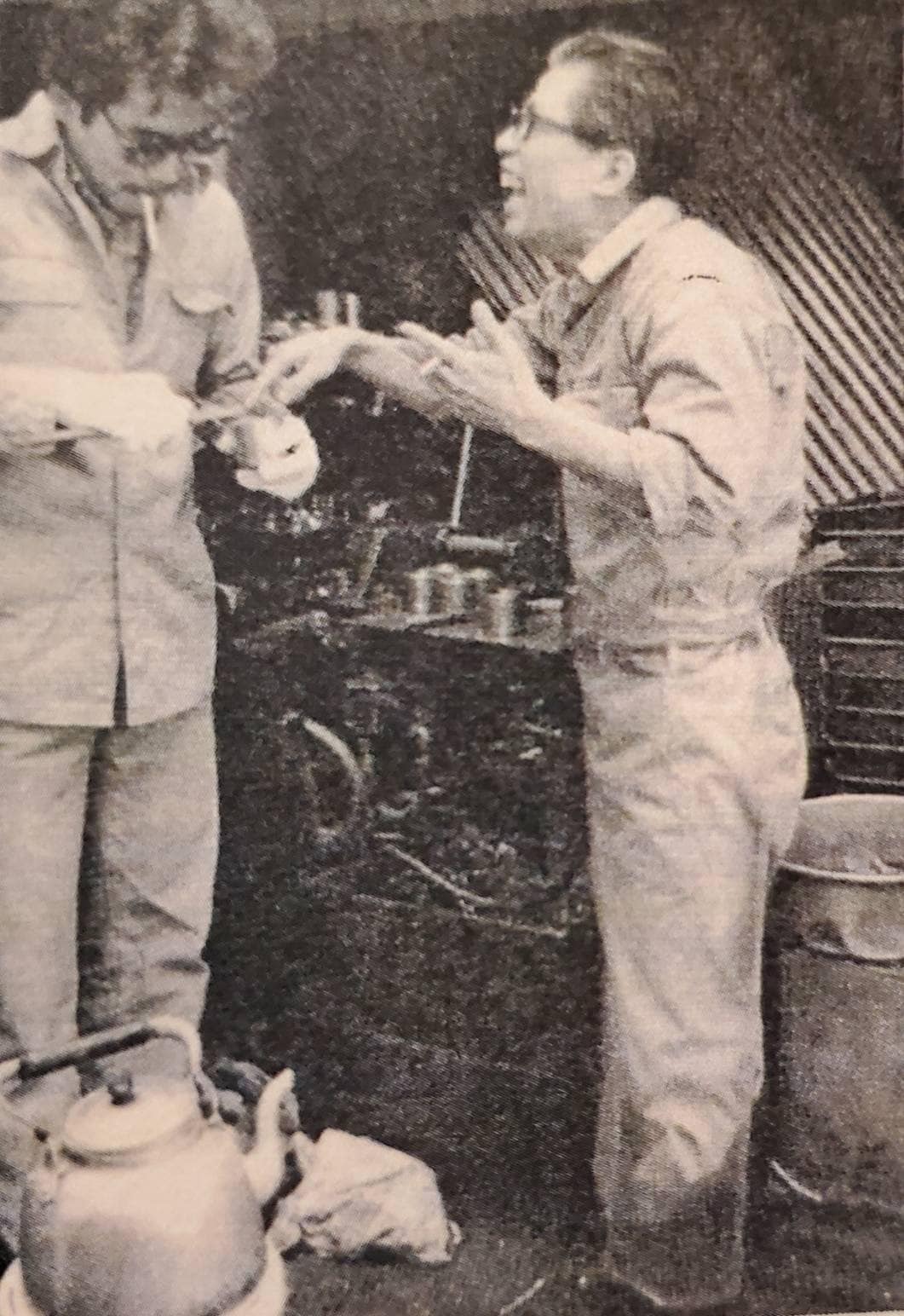 ノギスという測定器を使っている鈴木雅之（左）と、その不器用な姿を見て笑っている父親（右）。