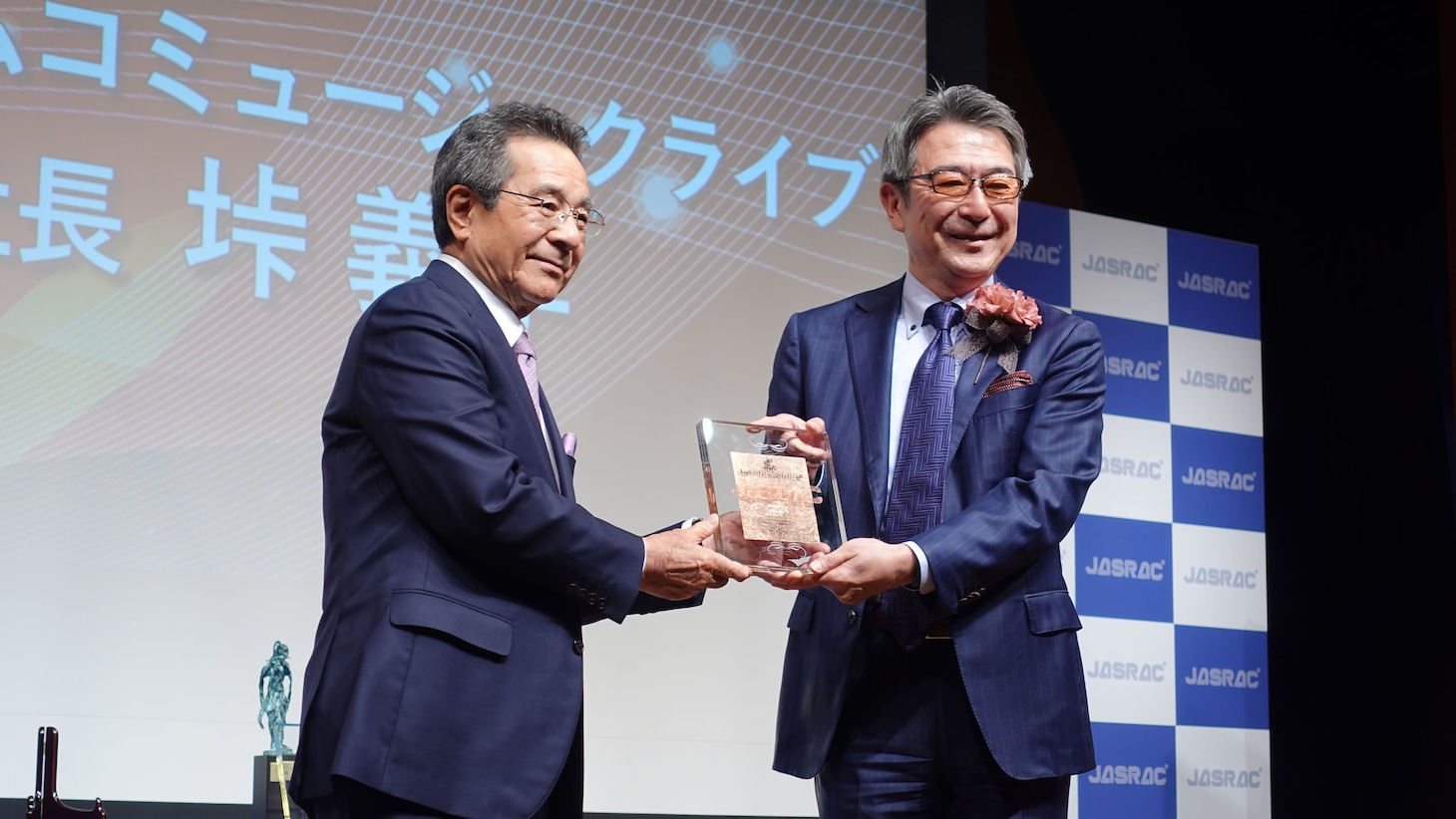 左からJASRAC会長の弦哲也、「閃光」の音楽出版社である株式会社バンダイナムコミュージックライブの垰義孝代表取締役社長。