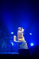 椅子に腰掛けて歌う柏木ひなた。