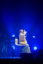 椅子に腰掛けて歌う柏木ひなた。