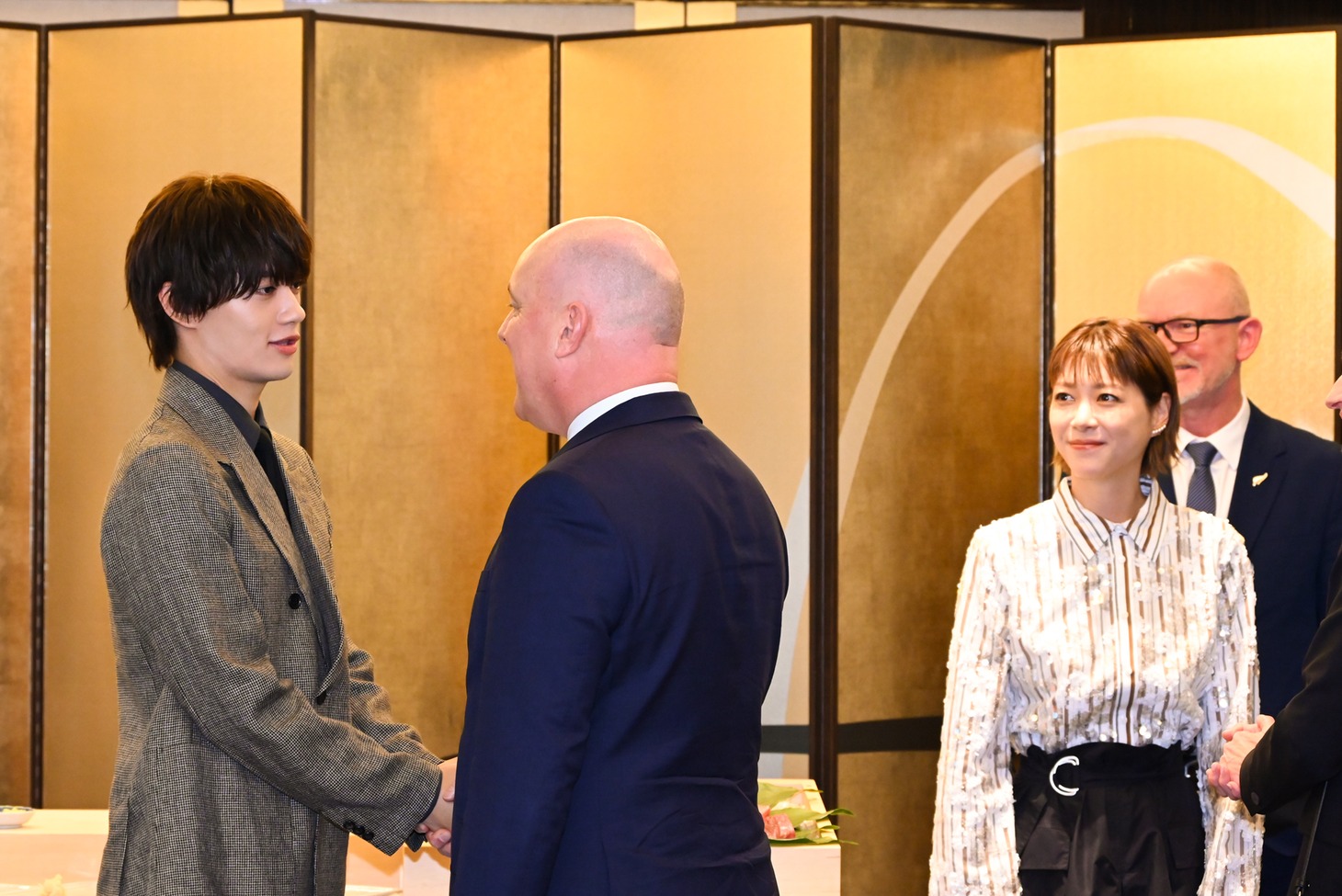 クリストファー・ラクソン首相（左から2番目）に挨拶するM!LK佐野勇斗（左）。それを見守る上野樹里（右）。