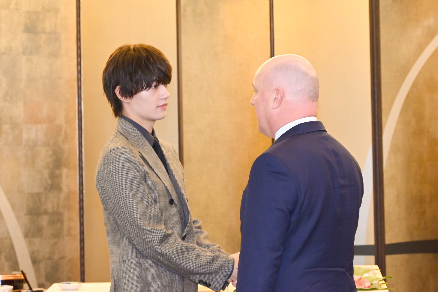 クリストファー・ラクソン首相（右）と握手するM!LK佐野勇斗（左）。
