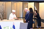 鮨かねさかの職人に話を聞くクリストファー・ラクソン首相夫妻。