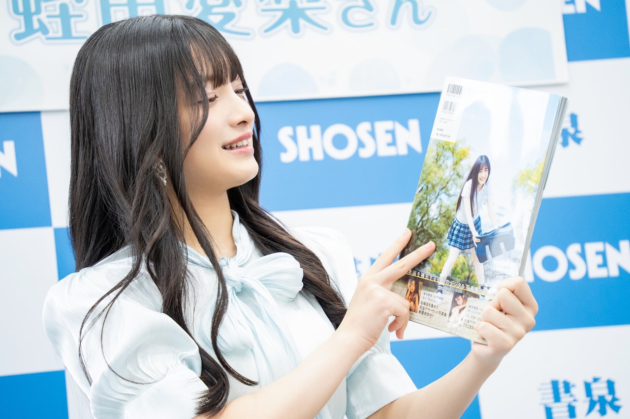 制服姿のカットが使われた写真集の裏表紙を見る蛭田愛梨（虹の