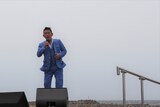 強風の中で歌う福田こうへい。