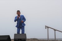 強風の中で歌う福田こうへい。