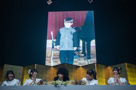 幼少期の竜人くんがスクリーンに大写しになり、会場の清家とともに歓声を上げる夫人たち。