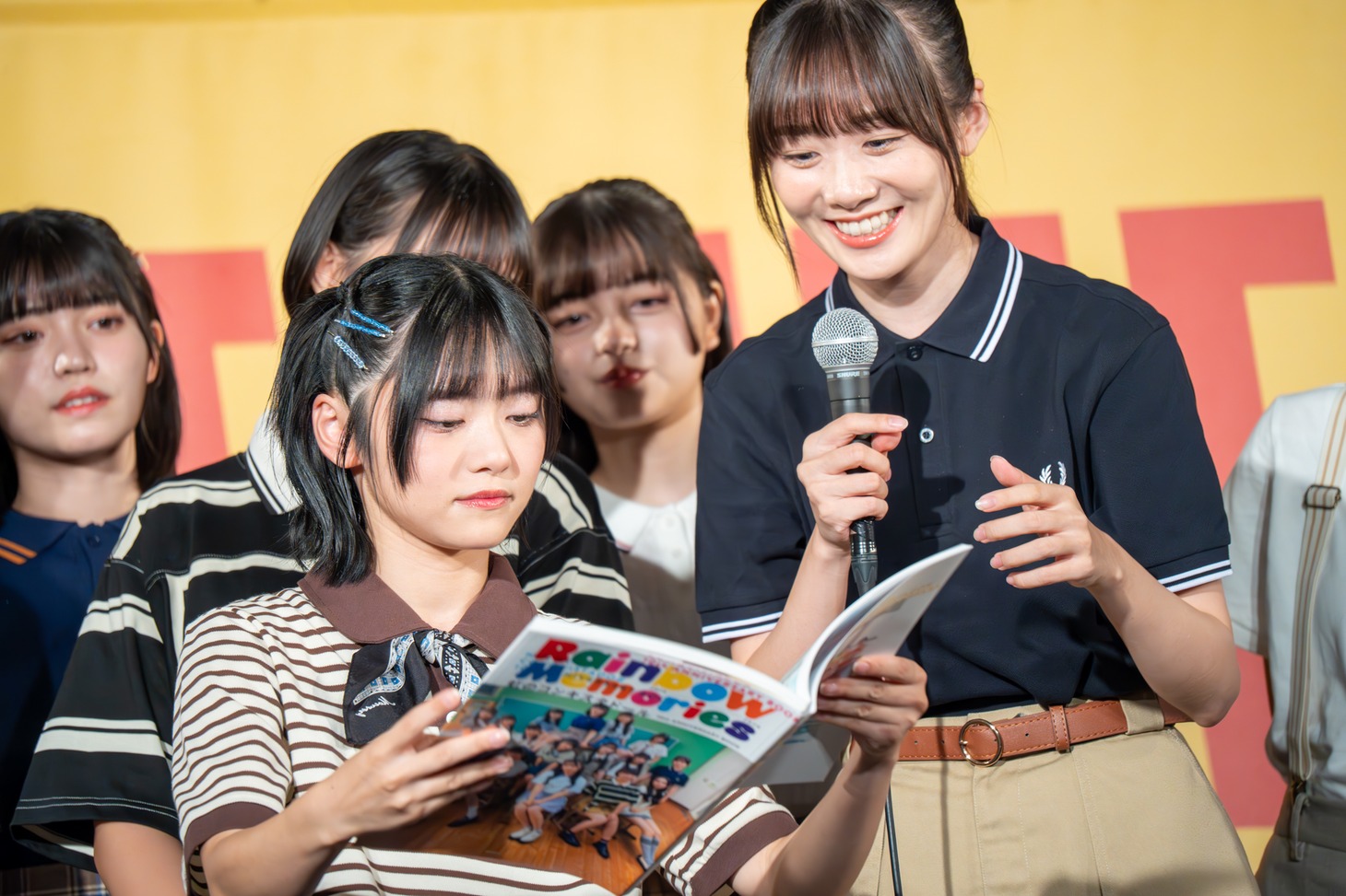 鶴見萌（右）のお気に入りカットが載っているページを広げる岡田彩夢（左）。