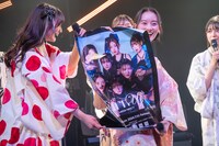 プレゼント用のポスターを見せるSARAとMIYU。