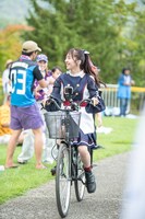 自転車で客席を回る真山りか。