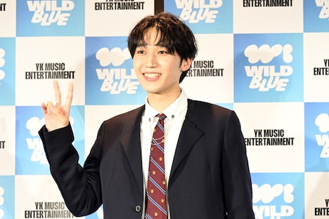 ポーズを求められ、とっさにピースする鈴川直哉。