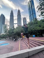 クアラルンプールの高層ビル、ペトロナスツインタワーの前にあるKLCC公園でパルクールごっこをする慈栄くん。