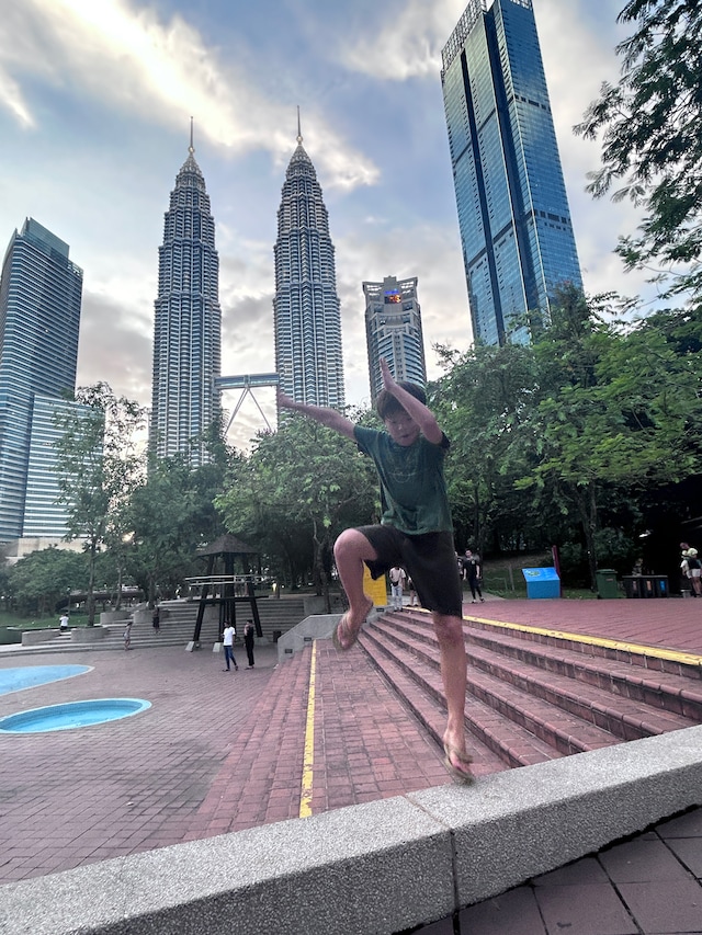 クアラルンプールの高層ビル、ペトロナスツインタワーの前にあるKLCC公園でパルクールごっこをする慈栄くん。