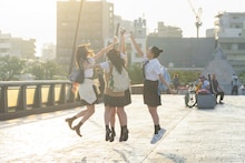 推しキャラグッズを手にしてハイタッチする説田詩央里（石塚瑶季）、角村若菜（清水理央）、梁取茜（宮地すみれ）、門林萌絵（山下葉留花）。(c)2024映画「ゼンブ・オブ・トーキョー」製作委員会