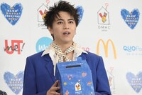 募金箱を大事そうに抱えるタカシ。