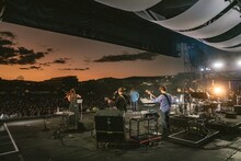 美しい夕焼け空が広がる中、演奏するASKAとバンドメンバー。（撮影：井上嘉和）