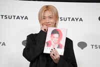 登壇してすぐに写真集の表紙と同じポーズを決めるユウタ（NCT 127）。