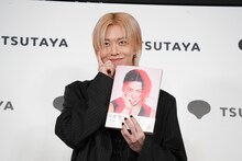 登壇してすぐに写真集の表紙と同じポーズを決めるユウタ（NCT 127）。