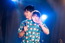 堂島孝平のお面を持つ堂島孝平。「ブツブツちあきTシャツ3」を着ている。（撮影：曽我美芽）