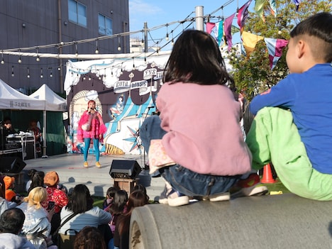 土管に座ってチャラン・ポ・ランタンのステージを観覧する子供たち。