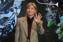 はにかみながら手を振る小室哲哉（TM NETWORK）。
