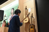 待ち時間にギターをチェックする松崎しげる。