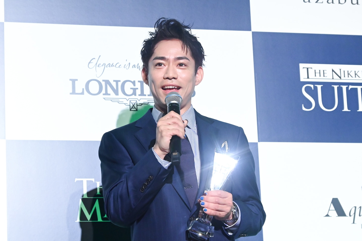 トロフィーを手に持つ高橋大輔。青いネイルが際立っている。