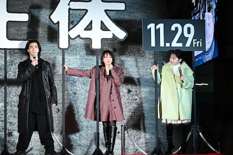 強い風が吹いて「正体」のオブジェが倒れそうになり、それを押さえる吉岡里帆(中央)、山田杏奈(右)、仁王立ちの横浜流星(左)。