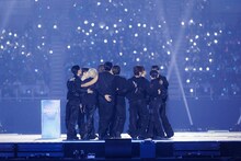 大賞受賞を知らされ、立ち上がり身を寄せ合うSEVENTEEN。