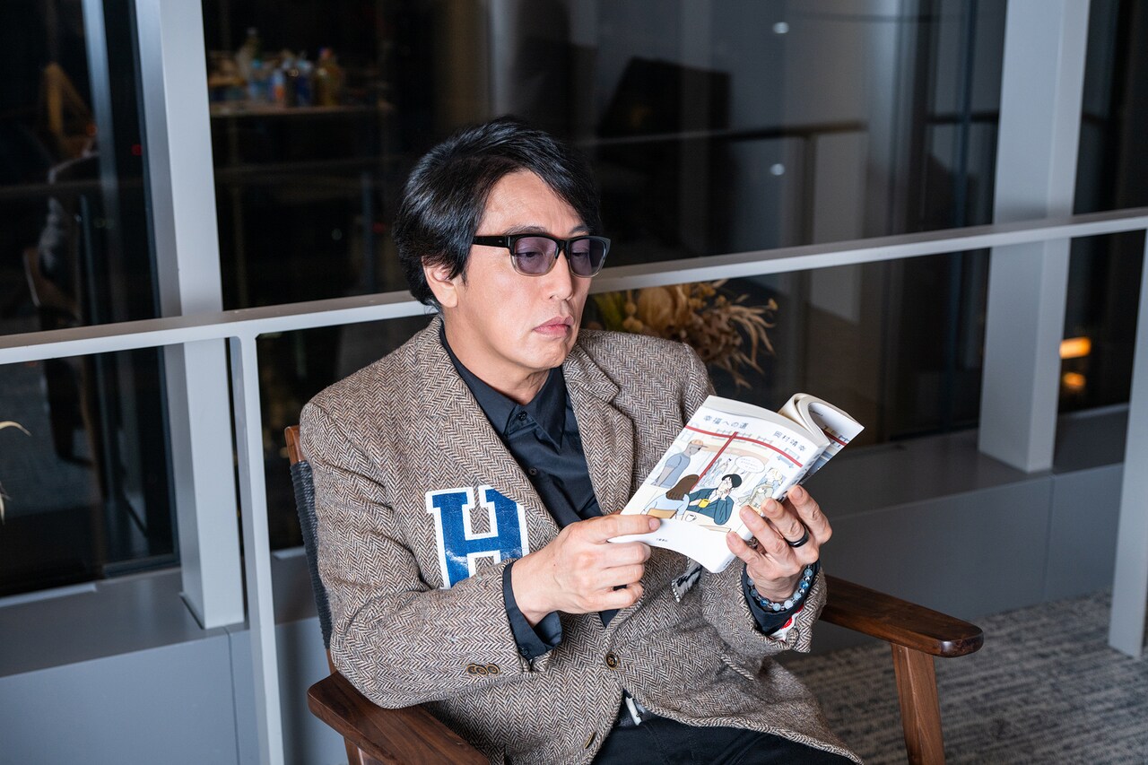 幸福への道」を手にした岡村靖幸。 - 岡村靖幸の最新対談集は
