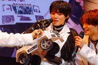 長野凌大からのプレゼント・ミニカーをまじまじと見る小泉光咲。車体にはメンバーの写真や長野が1人で撮り下ろしたプリクラが貼られている。（撮影：HannaTAKAHASHI）